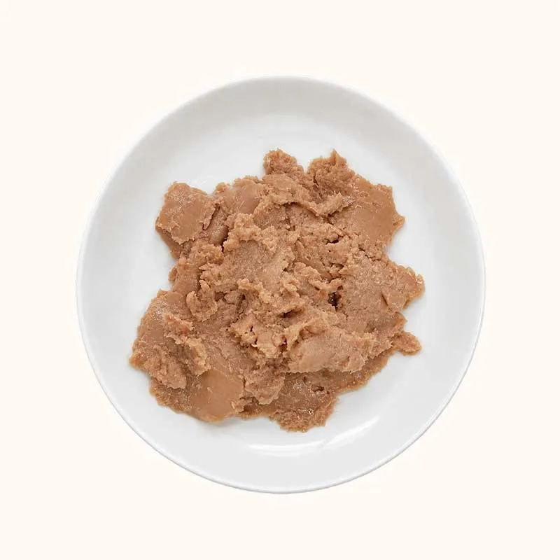 Mound of brown minced wet cat food on a white plate for Staple Meal Package